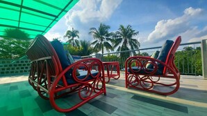 Terraza al aire libre con vistas a palmeras y un cielo despejado.