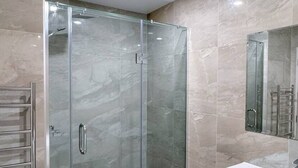 A modern bathroom with a glass-enclosed shower, a white vanity, and a large mirror. - 3BR Home • Parking • Sleeps 6 • Near Transport (Panmure)