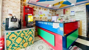 A hotel reception desk with a colorful geometric ceiling design, a digital kiosk, and a patterned carpet. - CAMERON KEA FARM HOTEL (Brinchang)
