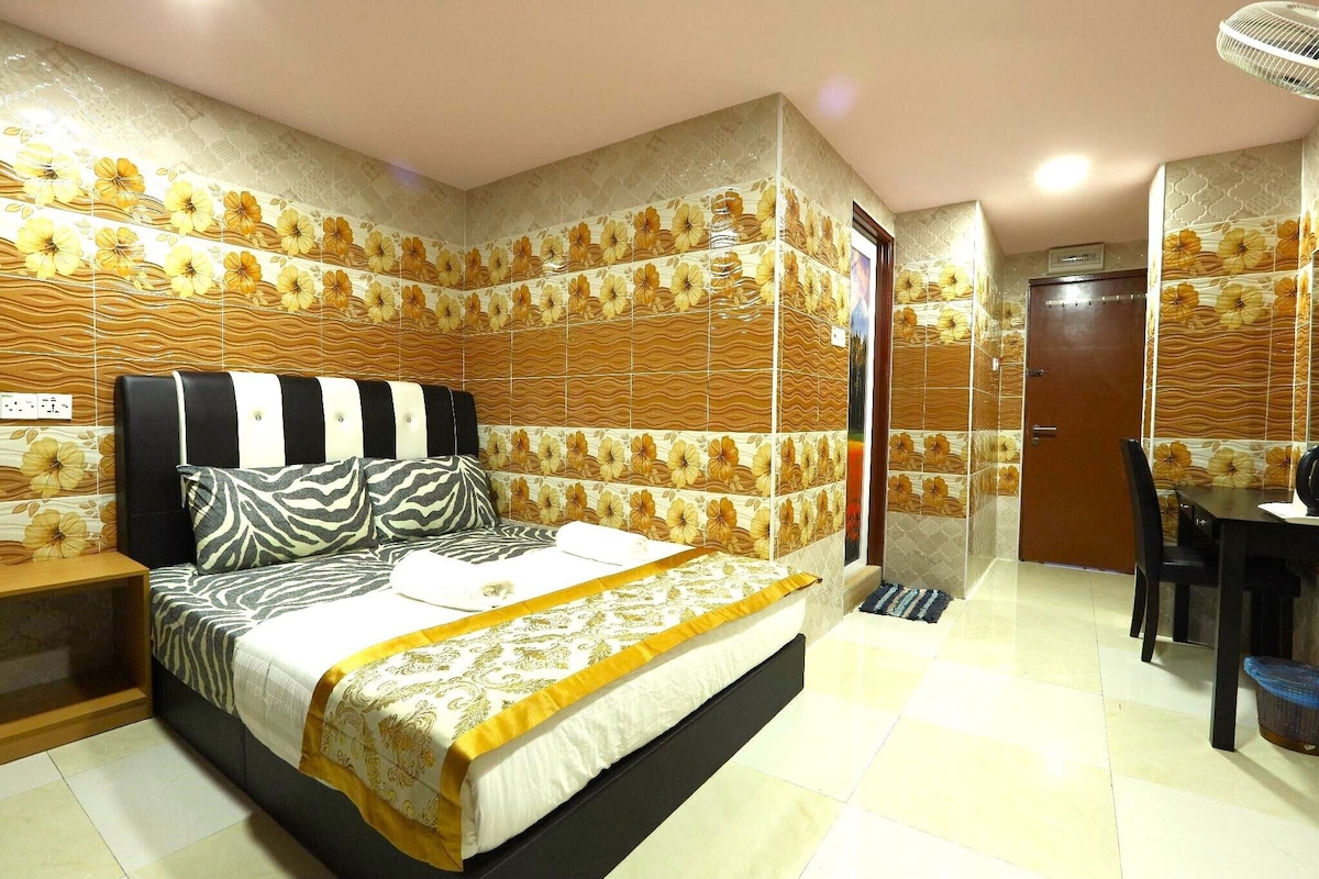 A bedroom with a bed, a bedside table, a desk, and a chair.