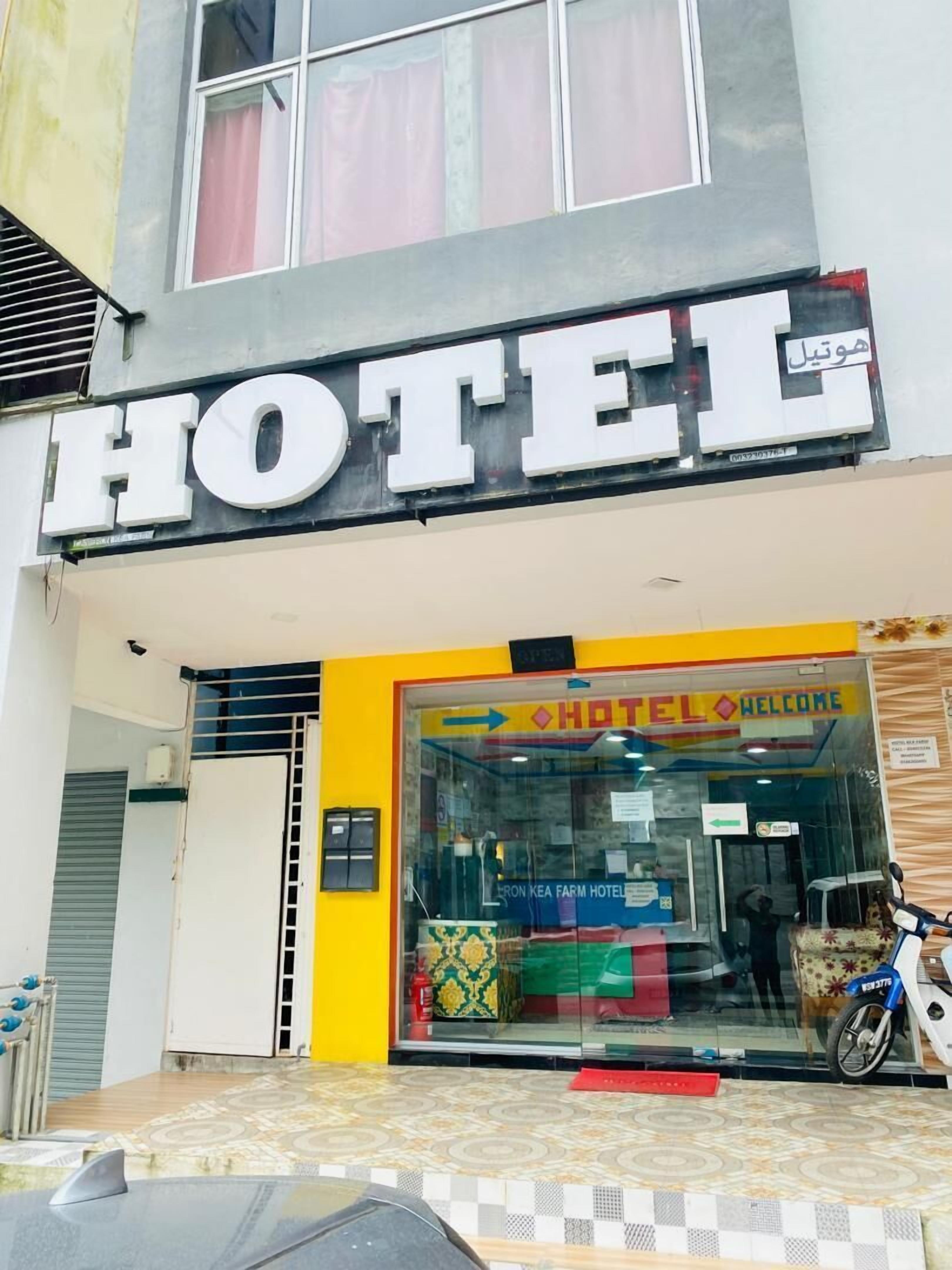A hotel entrance with a large sign reading "HOTEL" and a welcome sign inside the entrance.