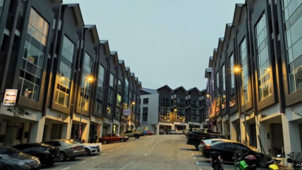 A street view of a modern building complex with multiple parking spaces and parked cars. - CAMERON KEA FARM HOTEL (Brinchang)