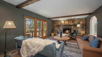 Télévision, cheminée, lecteur de DVD, livres