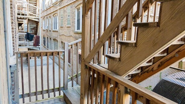 A wooden staircase with a metal railing leading to a balcony. - Vintage Escape 1BR Two Blocks Away From Beach (Chicago)
