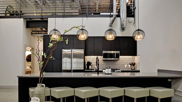 A modern kitchen with a central island, stainless steel appliances, and pendant lighting. - 3BR Luxury Loft Near Downtown & Frost Bank Center (San Antonio)
