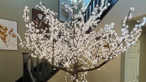Eine Treppe mit einer baumförmigen Lichtinstallation in der Mitte.