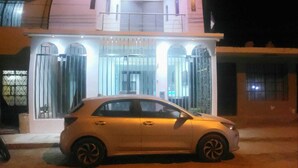 A two-story building with a car parked in front. - hospedaje pueblo viejo (San Luis de Cañete)