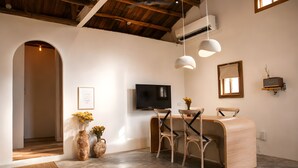 A modern interior with a wooden reception desk, two chairs, a flat-screen TV, and a ceiling fan. - Twilight Stone (New Taipei City)