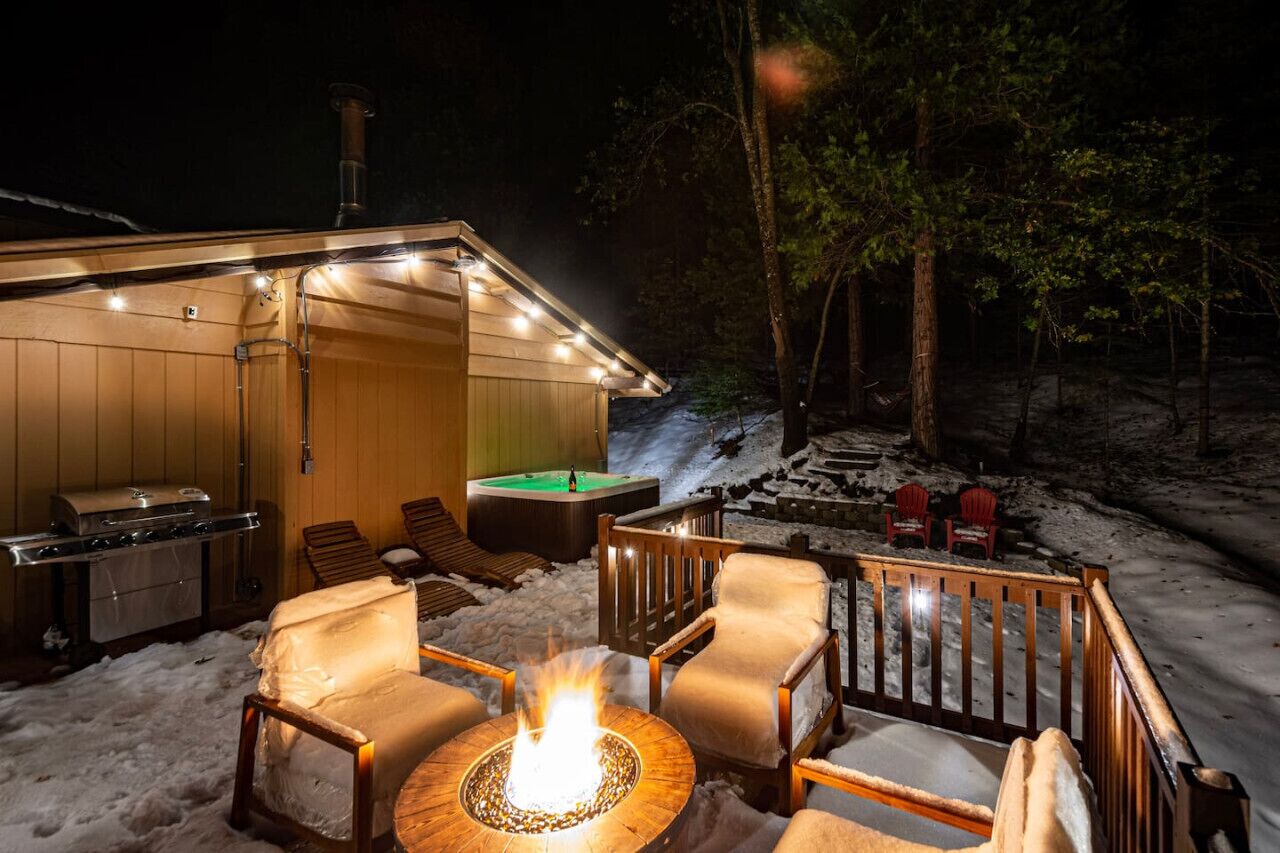 A cozy outdoor area with a fire pit, lounge chairs, and a barbecue grill.