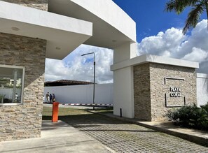 A modern building with a stone facade and a sign reading "Playa Coral". - Playa Coral Condo in Paradise F22 (Punta Cana)