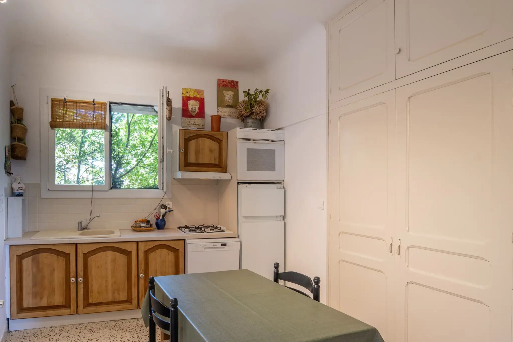 Une cuisine de taille réduite, dotée de meubles en bois, d’un évier, d’une cuisinière et d’un four à micro-ondes.
