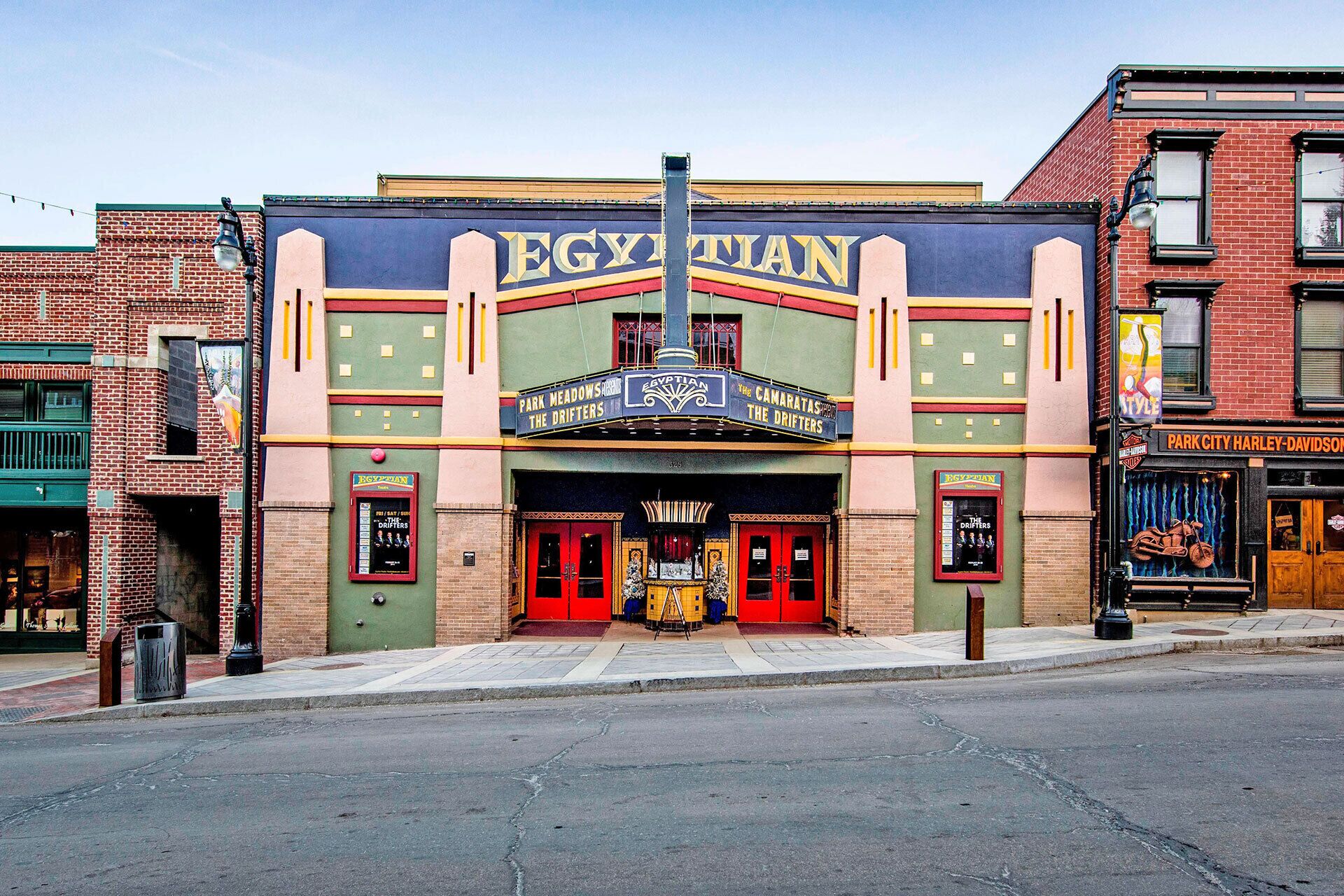 A theater with a marquee reading "EGYPTIAN" and "PARK MEADOWS THE DRIFTERS".
