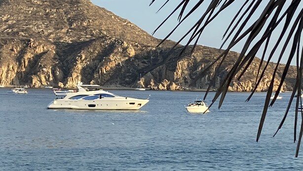 A beach with a yacht and a smaller boat in the water, with rocky cliffs in the background. - Pueblo Bonito Sunset Beach, Los Cabos, Ocean View (Cabo San Lucas)