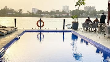 Una piscina al aire libre, camas de piscina gratis, sombrillas