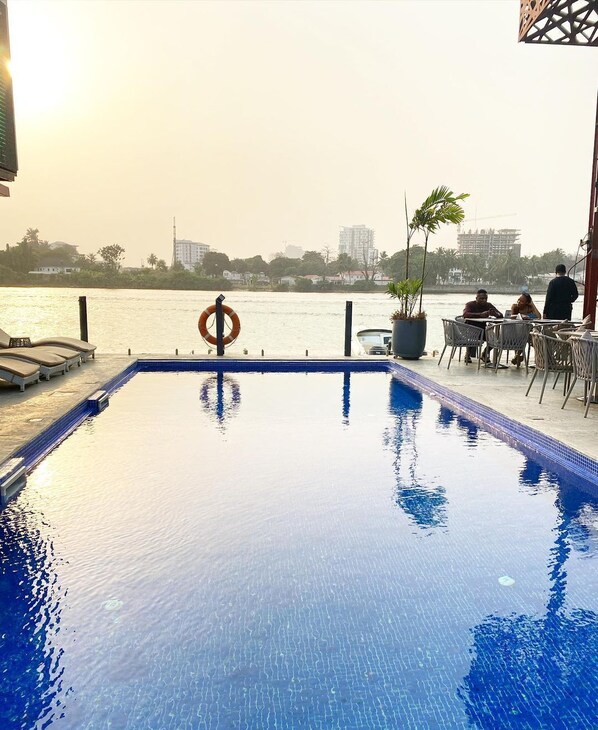 Una piscina al aire libre, camas de piscina gratis, sombrillas
