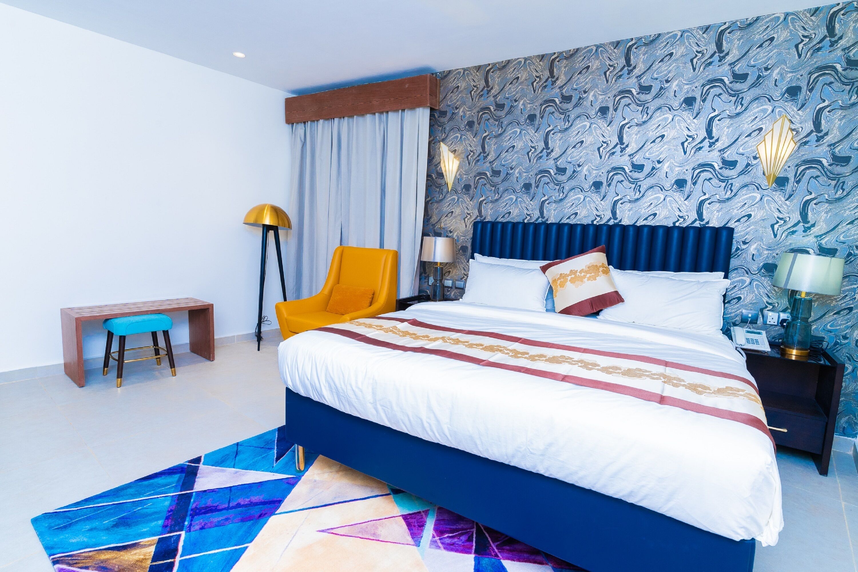 Ein modernes Hotelzimmer mit einem großen Bett, einem Schreibtisch und einem Stuhl.