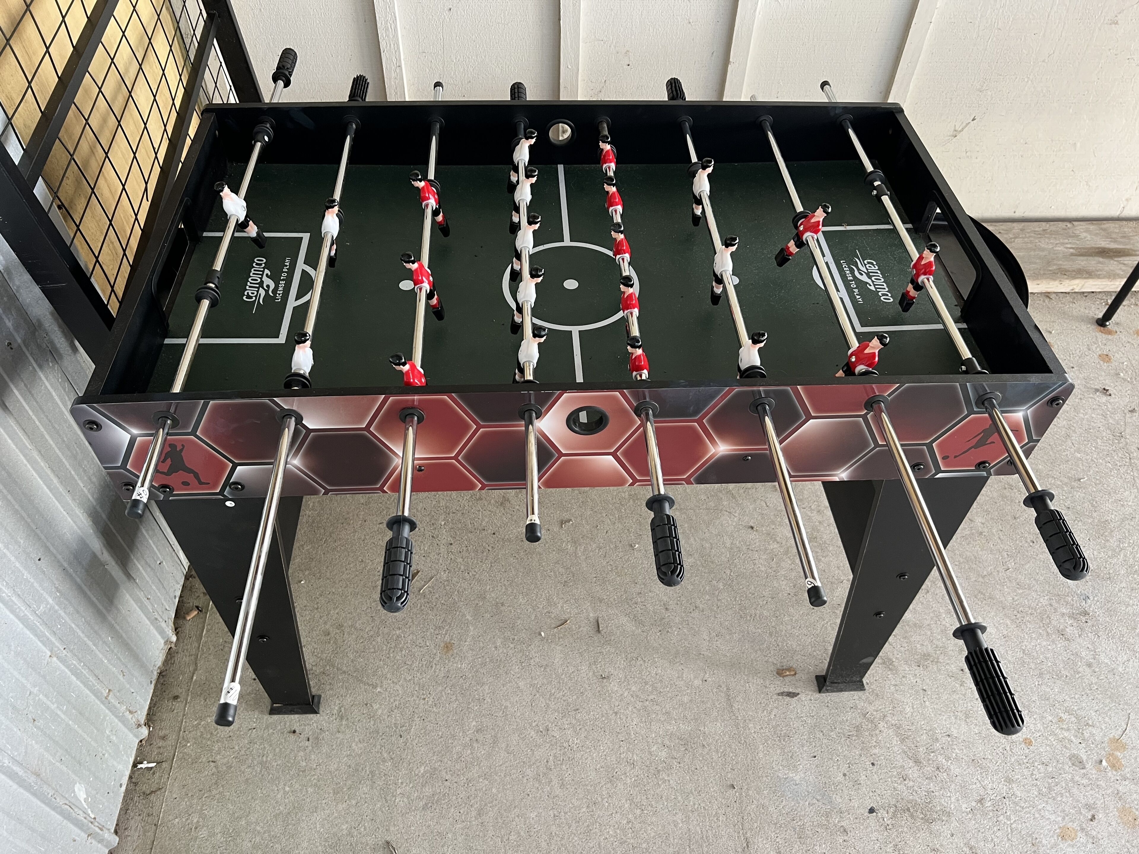 Una mesa de fútbol de mesa con un diseño hexagonal y un logotipo en el lateral.
