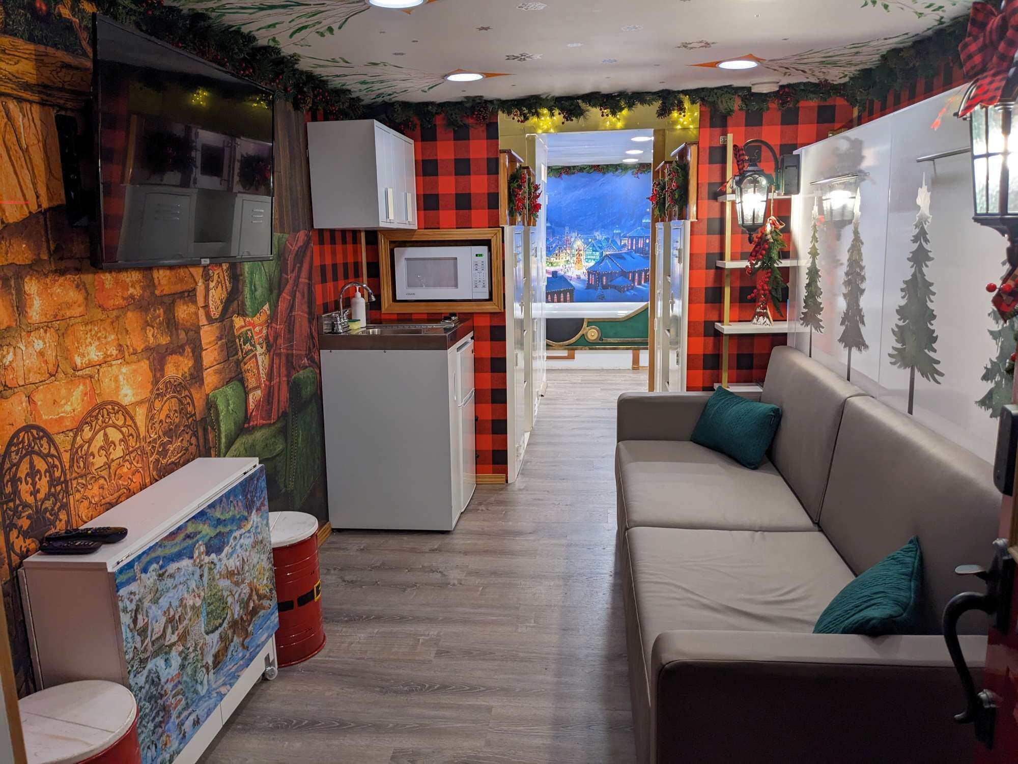 A cozy room with a kitchenette, a sofa, and a mural on the wall.