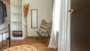 Ein Zimmer mit Bett, Kleiderschrank, Stuhl und Tür.