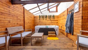 Eine Holzhütte mit Whirlpool, Holzbänken und einem gelben Teppich.