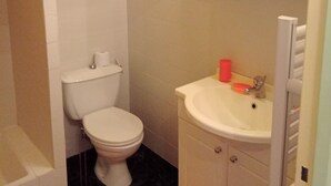 A bathroom with a toilet, sink, and shower.