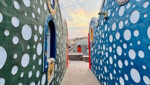 Un camino serpentea entre una serie de edificios con diseños únicos y motivos circulares.