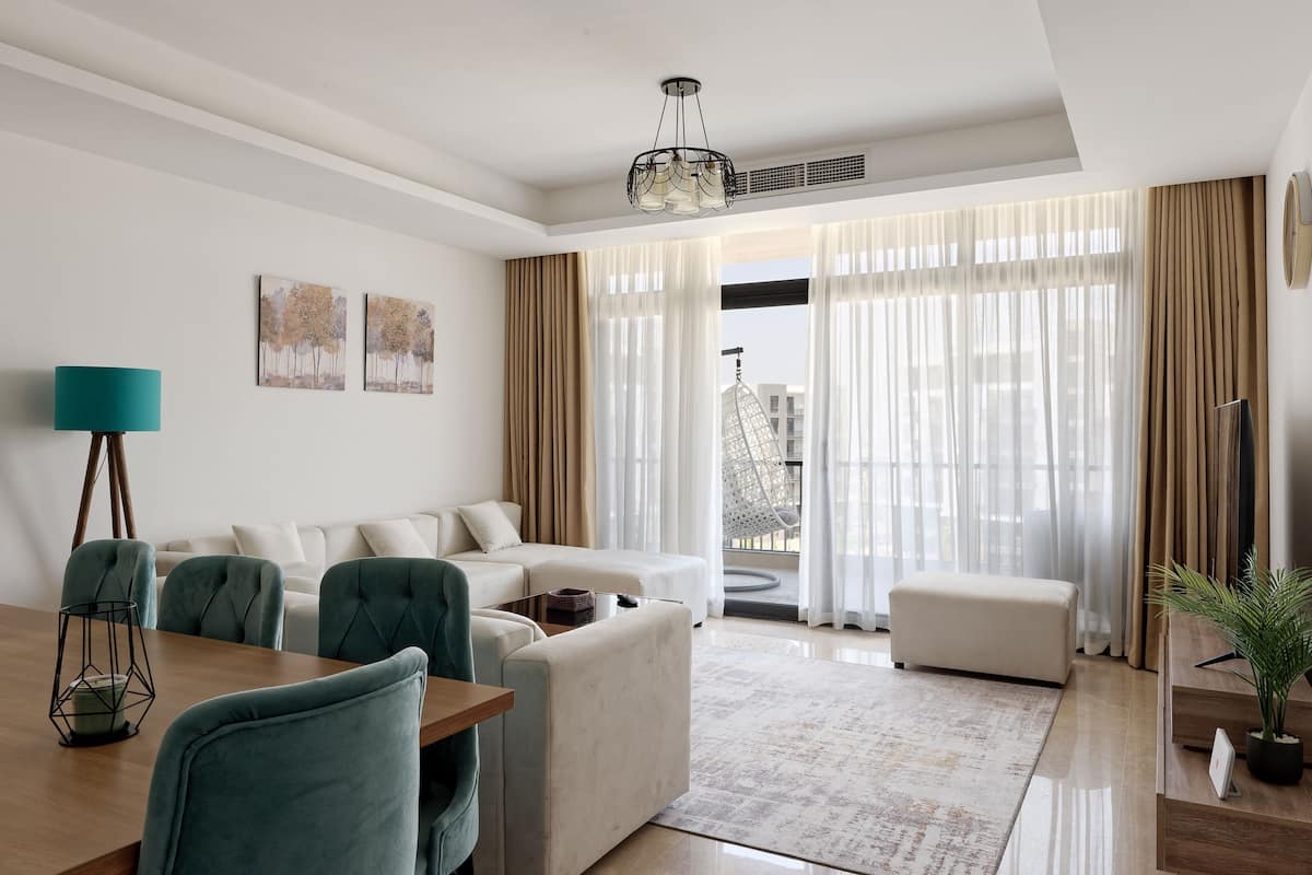 A modern living room with a sofa set, a dining table, and a potted plant.