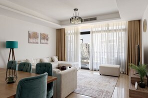 A modern living room with a sofa set, a dining table, and a potted plant. - VESTA - Cairo Festival City Residence (New Cairo)