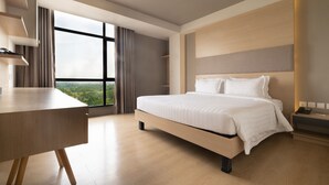 A modern hotel room with a large bed, a desk, and a view of the city through large windows. - Areca Hotel (Yangon)