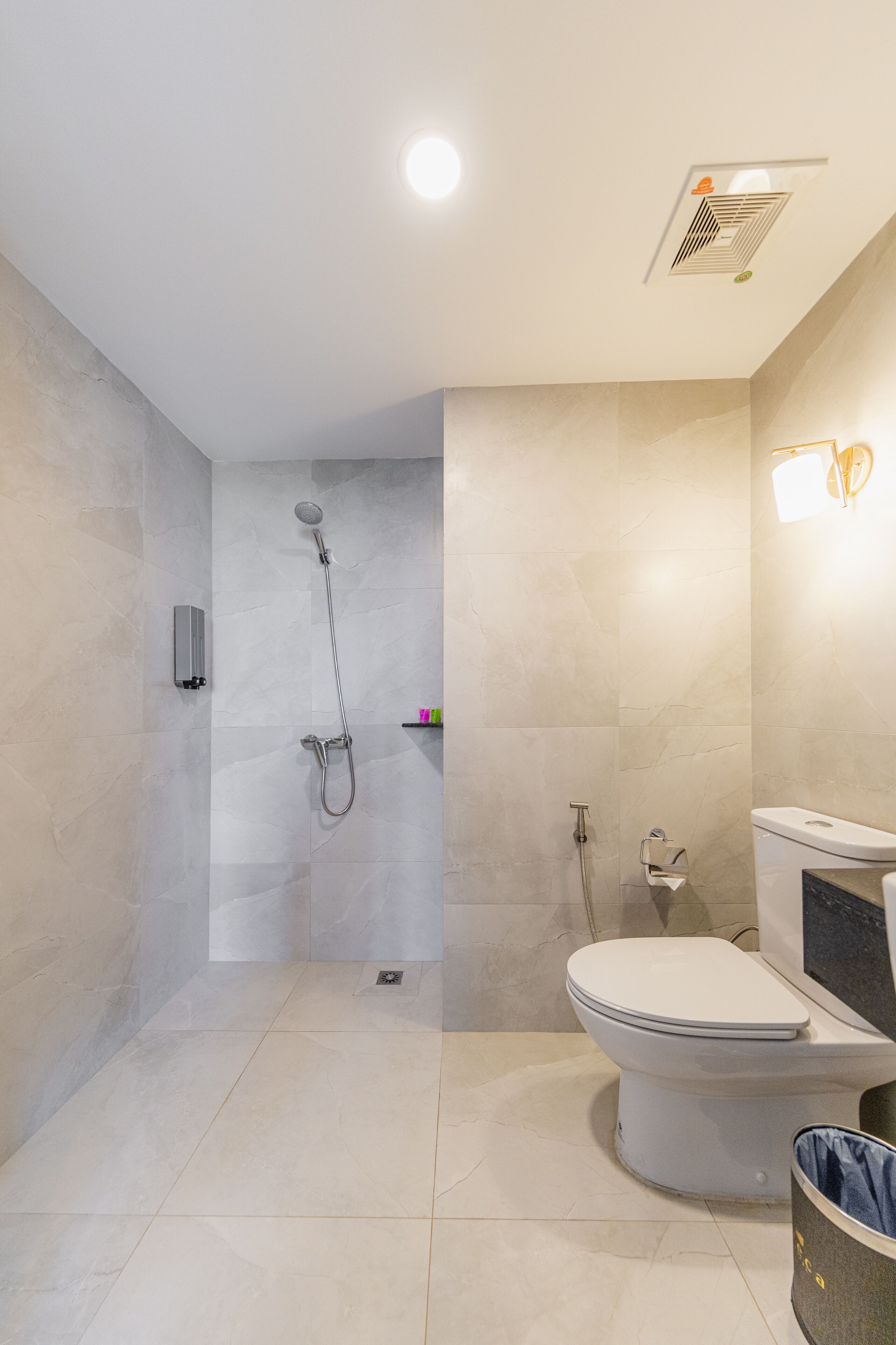 Un baño moderno con ducha, inodoro y un calentador de pared.