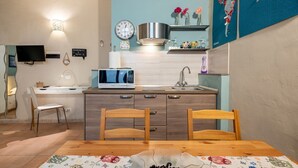 Eine moderne Küche mit Mikrowelle, Spüle und Holzkohlenstühlen an einem Esstisch.