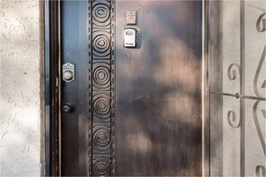 A metallic elevator door with a security keypad and a lock.