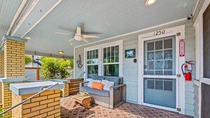 A covered outdoor seating area with a sofa and a table, a fire extinguisher, and a door labeled "1250".