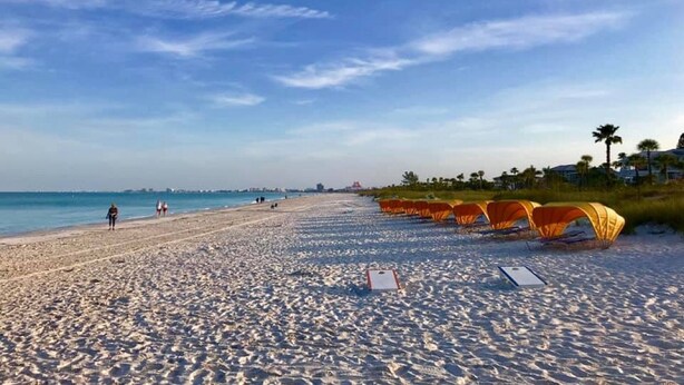 A beach with tents and a clear sky.