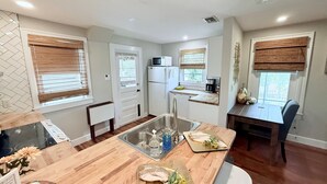 Une cuisine moderne dotée d’un plan de travail en bois, d’un évier et d’un coin repas avec une table et des chaises.