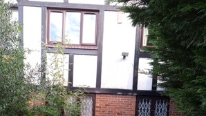 A brick building with a window and a metal gate.