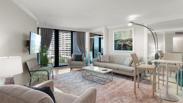 Ein modernes Wohnzimmer mit Sofa, Sesseln, einem Couchtisch und einem Essbereich mit Tisch und Stühlen.