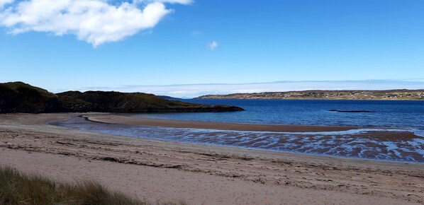 Enjoy a serene beach experience with gentle waves lapping onto the shore.
