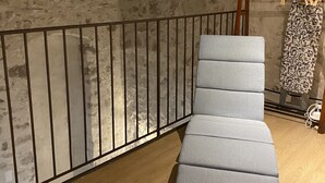 Ein Ecksofa in einem Raum mit freiliegenden Holzbalken und Steinwänden.