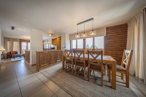 A modern kitchen with wooden cabinets, a central island, and pendant lighting.