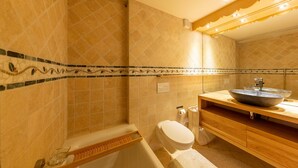 Ein Badezimmer mit Badewanne, Toilette und einem Waschtisch mit großem Becken.