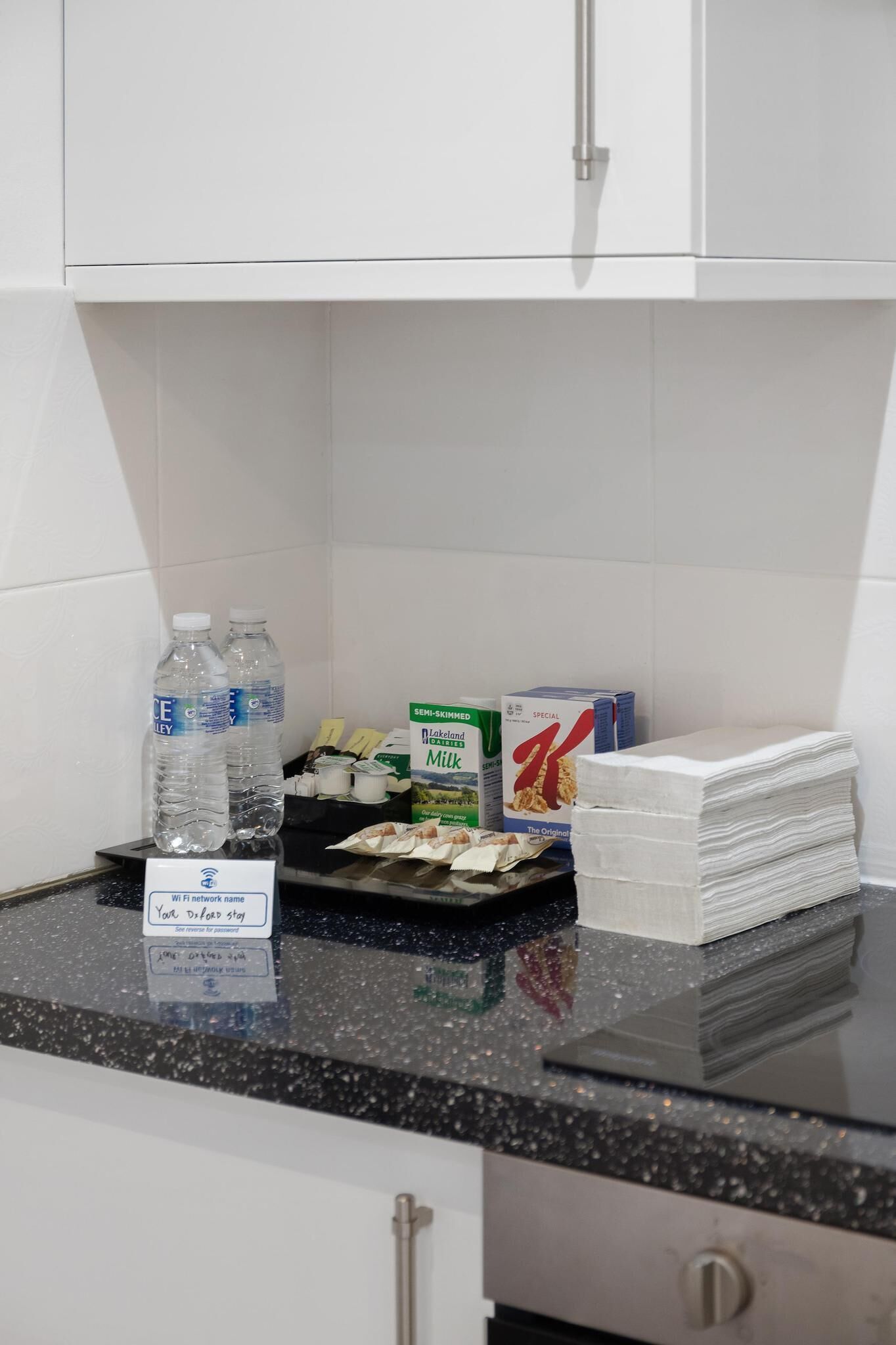 Eine Küchenarbeitsplatte mit Wasserflaschen, Milchkartons und Küchenpapier.