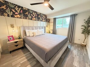 A bedroom with a bed, a nightstand, a wall-mounted light, a ceiling fan, and a window with curtains. - 🌴Historic Old Town Scottsdale, Modern Oasis & Spa, 5G WIFI, Walkable (Scottsdale)