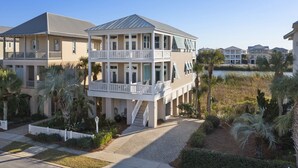 A multi-story residential building with balconies, a covered walkway, and a landscaped garden with palm trees. - Aqua Easy - Destin Pointe, Gulf Views, Lakefront, Free Beach Service, Cmty Pool! (Destin)