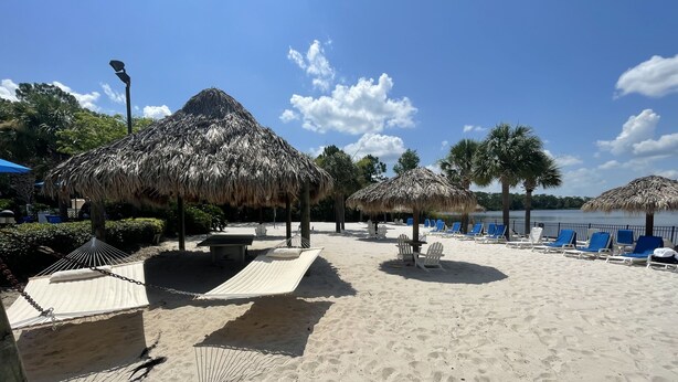 A beach with thatched umbrellas, lounge chairs, and hammocks. - Spacious 1st floor in Bahama Bay, Resort Amenities. Disney, less than 15 mins (Davenport)