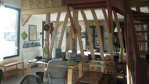 Un intérieur rustique avec des poutres apparentes, un bureau avec une chaise et une bibliothèque.