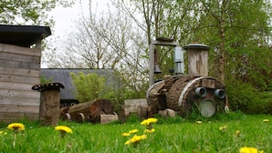 Une construction rustique en bois, dotée d’un clocher en métal et d’un mécanisme à roue en bois.