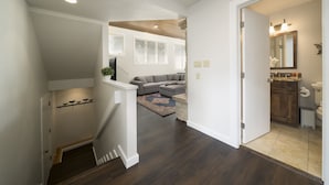 Een modern interieur met een trap die leidt naar een woonruimte, keuken en badkamer.