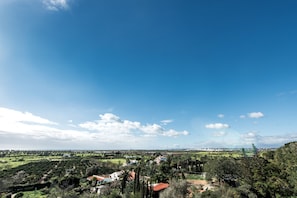 A panoramic view of a rural landscape with houses, trees, and a clear sky.