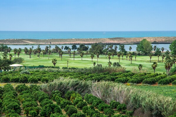 A golf course with a view of the ocean and a rocky shoreline.